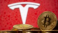 FILE PHOTO: Representations of virtual currency bitcoin are seen in front of Tesla logo in this illustration taken, February 9, 2021. REUTERS/Dado Ruvic/File Photo
