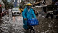 A man wearing a face shield for protection against the coronavirus disease (COVID-19) rides a bicycle on a flooded street in Manila, Philippines, July 21, 2021. REUTERS/Eloisa Lopez/File Photo