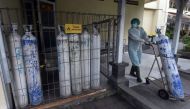 A medical worker pulls an oxygen cylinder to be delivered to the emergency ward at a government-run hospital amid the coronavirus disease (COVID-19) outbreak in Denpasar, Bali, Indonesia, July 23, 2021, in this photo taken by Antara Foto July 23, 2021. An