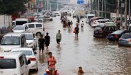 People wade through floodwaters following heavy rainfall in Zhengzhou, Henan province, China July 23, 2021. (REUTERS/Aly Song)