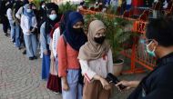 A girl has her temperature checked as she arrives to receive China's Sinovac Biotech vaccine against the coronavirus disease (COVID-19) during a mass vaccination program at Ancol amusement park in Jakarta, Indonesia, July 24, 2021. REUTERS/Willy Kurniawan