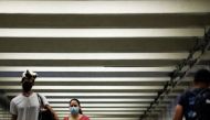 People wear masks as they pass through a pedestrian subway as cases of the infectious coronavirus Delta variant continue to rise in New York City, New York, U.S., July 26, 2021. REUTERS/Andrew Kelly

