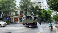 Men wearing personal protective equipment (PPE) disinfect a street as the city is under lockdown, during the coronavirus disease ( COVID-19 ) outbreak in Hanoi, Vietnam July 26, 2021. REUTERS/Stringer