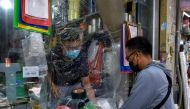 A man buys goods at a shop covered with plastic amid the coronavirus (COVID-19) pandemic, in Hanoi, Vietnam, May 31. REUTERS/Thanh Hue/File Photo