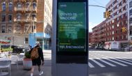 A pedestrian walks past an ad encouraging those eligible to sign up for COVID-19 vaccine appointments in the Manhattan borough of New York City, New York, U.S., March 29, 2021. REUTERS/Caitlin Ochs