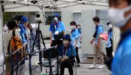 Staff members wearing protective masks conduct body temperature checks at an entrance to the National Stadium, the main stadium of Tokyo 2020 Olympic and Paralympic Games in Tokyo, Japan July 31, 2021. Reuters/Issei Kato