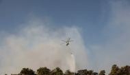 A firefighting helicopter drops water on a wildfire near Marmaris, Turkey, July 31, 2021. (Reuters/Umit Bektas)
