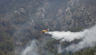 A firefighting plane from Spain drops water to a wildfire near Koycegiz, Turkey, August 4, 2021. REUTERS/Umit Bektas