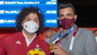 Qatar Olympic Committee President Sheikh Joaan bin Hamad Al Thani, poses for a photograph with Fares Ibrahim after the Qatari weightlifter won the country's first ever Olympic gold medal on Saturday.