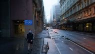 A pedestrian wearing a protective face mask walks through the deserted city centre at morning commute hour during a lockdown to curb the spread of a coronavirus disease (COVID-19) outbreak in Sydney, Australia, June 30, 2021. REUTERS/Loren Elliott


