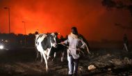 Residents evacuate the area with their animals as a wildfire rages in the suburb of Thrakomakedones, north of Athens, Greece, on August 7, 2021. Reuters/Giorgos Moutafis