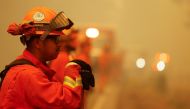 A member of the California Department of Corrections and Rehabilitation Vallecito Fire Crew watch a section of road for spot fires to slow the spread of the Dixie Fire, a wildfire near the town of Westwood, California, U.S. August 8, 2021. REUTERS/Fred Gr