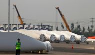 A security guard stands next to blades and bases for wind turbines on the grounds of the Vestas Wind Technology company's factory, located in the northern Chinese city of Tianjin September 14, 2010. Reuters/David Gray/File Photo