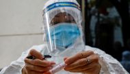 A health worker wearing a protective suit labels a sample tube at the National Convention Center, the venue for the 13th National Congress of the Communist Party of Vietnam, during the coronavirus disease (COVID-19) outbreak in Hanoi, Vietnam January 29, 