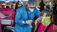 A health worker vaccinates a foodpanda delivery rider with Sinovac COVID-19 vaccine in a shopping mall's parking lot turned into a drive-thru vaccination site, in Quezon City, Metro Manila, Philippines, August 13, 2021. REUTERS/Eloisa Lopez