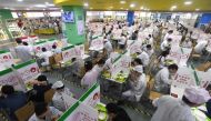 Employees dine at tables with partitions during dinner time at the canteen of a Lenovo factory following the coronavirus disease (COVID-19) outbreak in Wuhan, Hubei province, China August 13, 2021. Picture taken August 13, 2021. China Daily via REUTERS