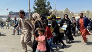 People try to get into Hamid Karzai International Airport in Kabul, Afghanistan August 16, 2021. REUTERS