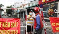 A man living in an area under lockdown receives food through a barricade during the coronavirus disease (COVID-19) pandemic in Ho Chi Minh City, Vietnam July 20, 2021. REUTERS/Stringer/File Photo