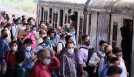 Commuters wearing protective face masks wait to board a suburban train after authorities resumed train services for vaccinated passengers amid the coronavirus disease (COVID-19) pandemic, in Mumbai, India, August 17, 2021. REUTERS/Francis Mascarenhas