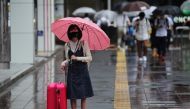A woman wearing a protective mask, amid the coronavirus disease (COVID-19) outbreak, stands in the rain in Fukuoka, Fukuoka Prefecture, Japan, August 17, 2021. REUTERS/Kim Kyung-Hoon