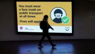 A person walks past a public health warning for passengers to wear face masks at a city centre transit station during a lockdown to curb the spread of an outbreak of the coronavirus disease (COVID-19) in Sydney, Australia, August 17, 2021. REUTERS/Loren E