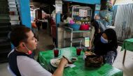 A diner shows her digital vaccination certificate at a restaurant, amid the coronavirus disease (COVID-19) outbreak in Kuala Lumpur, Malaysia August 20, 2021. REUTERS/Lim Huey Teng