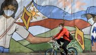 A man wearing a face mask and a face shield as protection against the coronavirus disease (COVID-19) passes by a mural dedicated to frontline workers, in Manila, Philippines, January 11, 2021. REUTERS/Lisa Marie David