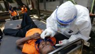A man with mental illness reacts as a healthcare worker takes a swab sample to test for the coronavirus disease (COVID-19) at a social home in Jakarta, Indonesia, August 23, 2021. REUTERS/Ajeng Dinar Ulfiana