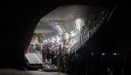 Afghans board a U.S. Air Force C-17 Globemaster III transport plane during an evacuation at Hamid Karzai International Airport, Afghanistan, August 22, 2021. Picture taken August 22, 2021. 