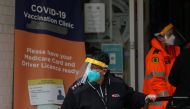 A staff member works at the front entrance of a coronavirus disease (COVID-19) vaccination clinic in the Bankstown suburb during a lockdown to curb an outbreak of cases in Sydney, Australia, August 25, 2021. REUTERS/Loren Elliott