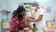 A healthcare worker holding a rose is vaccinated against COVID-19 at a medical centre in Mumbai, India, January 16, 2021. REUTERS/Francis Mascarenhas/File Photo