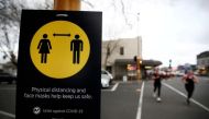 People jog past a social distancing sign on the first day of New Zealand's new coronavirus disease (COVID-19) safety measure that mandates wearing of a mask on public transport, in Auckland, New Zealand, August 31, 2020. REUTERS/Fiona Goodall/File Photo
