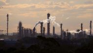 Birds and a plane are seen flying above emission from the chimneys of a chemical plant located near Port Botany in Sydney, Australia June 2, 2017. REUTERS/David Gray/File Photo