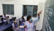 A teacher gives a lesson inside a classroom following the reopening of schools at 50% capacity for the students of classes 9 to 12 after months of closure due to the coronavirus disease (COVID-19) outbreak, at a government school in New Delhi, India, Sept