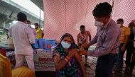 A woman receives a dose of COVAXIN coronavirus disease (COVID-19) vaccine manufactured by Bharat Biotech, during a vaccination drive organised by SEEDS, an NGO which normally specialise in providing relief after floods and other natural disasters, at an u
