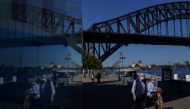 People in protective face masks walk past the Sydney Harbour Bridge during a lockdown to curb the spread of a coronavirus disease (COVID-19) outbreak in Sydney, Australia, September 3, 2021. REUTERS/Loren Elliott
