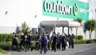 A police officer leads employees of a nearby store away from the scene of an attack at a shopping mall in Auckland, New Zealand, September 3, 2021. Stuff Limited/Ricky Wilson via Reuters