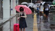 A woman wearing a protective mask, amid the coronavirus disease (COVID-19) outbreak, stands in the rain in Fukuoka, Fukuoka Prefecture, Japan, August 17, 2021. REUTERS/Kim Kyung-Hoon
