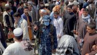 FILE PHOTO: A member of Taliban security forces stands guard among crowds of people walking past in a street in Kabul, Afghanistan September 4, 2021. REUTERS/Stringer/File Photo