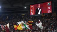 Roma fans wave flags as a picture of AS Roma coach Jose Mourinho is displayed on the big screen before the match REUTERS/Alberto Lingria