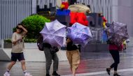 People walk on a street, as typhoon Chanthu approaches, in Shanghai, China September 13, 2021. REUTERS/Aly Song