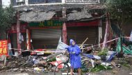 A person pushes a bicycle past damaged buildings, following an earthquake in Luzhou city of southwestern province of Sichuan, China September 16, 2021. cnsphoto/via REUTERS