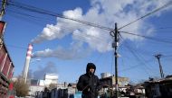 A man walks near a coal-fired power plant in Harbin, Heilongjiang province, China November 27, 2019. REUTERS/Jason Lee

