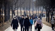 People wearing masks take a walk amid the coronavirus disease (COVID-19) pandemic at a Hanriver Park in Seoul, South Korea, February 21, 2021. REUTERS/Kim Hong-Ji/File Photo