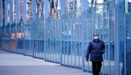 A woman wearing a protective face mask walks along a deserted city bridge during morning commute hours on the first day of a lockdown as the state of Victoria looks to curb the spread of a coronavirus disease (COVID-19) outbreak in Melbourne, Australia, J