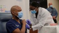 FILE PHOTO: Dr Yves Duroseau from Lennox Hill Hospital is inoculated with the Pfizer coronavirus disease (COVID-19) vaccine by Dr. Michelle Chester from Northwell Health at Long Island Jewish Medical Center in New Hyde Park, New York, U.S., December 14, 2