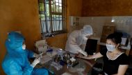 Medical specialists wearing protective suits collect blood sample from a woman who has returned after travelling to Da Nang, at a rapid testing center for coronavirus disease (COVID-19) outside Hanoi, Vietnam July 30, 2020. REUTERS/Kham/File Photo