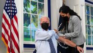 U.S. President Joe Biden holds up his sleeve to receive his coronavirus disease (COVID-19) booster vaccination in the Eisenhower Executive Office Building's South Court Auditorium at the White House in Washington, U.S., September 27, 2021. REUTERS/Kevin L