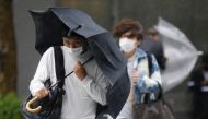 Men wearing protective masks amid the coronavirus disease (COVID-19) outbreak, make their way in the heavy rain caused by Typhoon Mindulle in Tokyo, Japan, October 1, 2021. REUTERS/Kim Kyung-Hoon