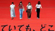 File photo: Women wearing protective masks, amid the coronavirus disease (Covid-19) outbreak, walk on a stair bearing a slogan cheering Japanese team during Tokyo 2020 Olympic Games in Tokyo, Japan, August 7, 2021. Reuters/Kim Kyung-Hoon/File Photo